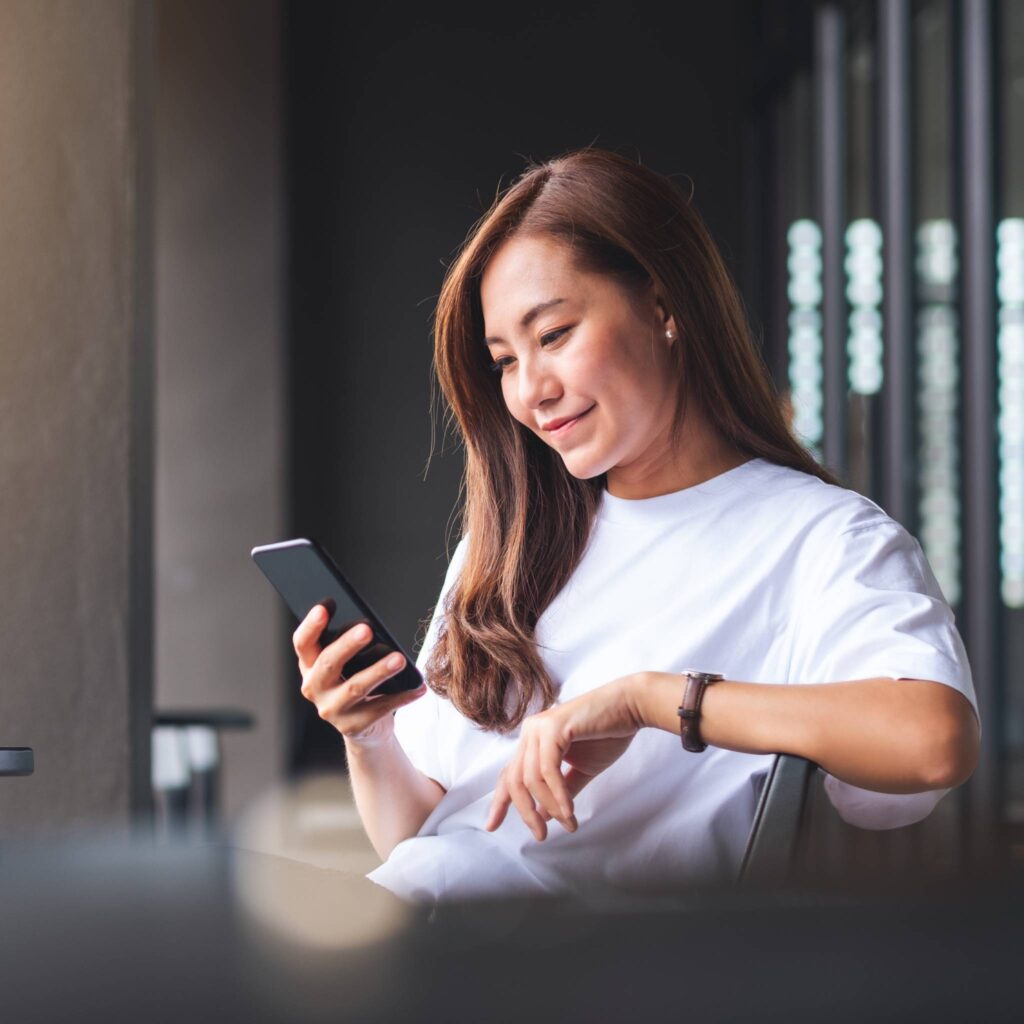 A professional checks her online account on her phone