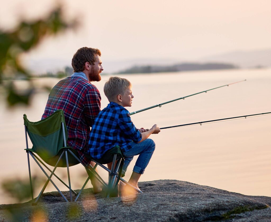 A father and son fish at dawn