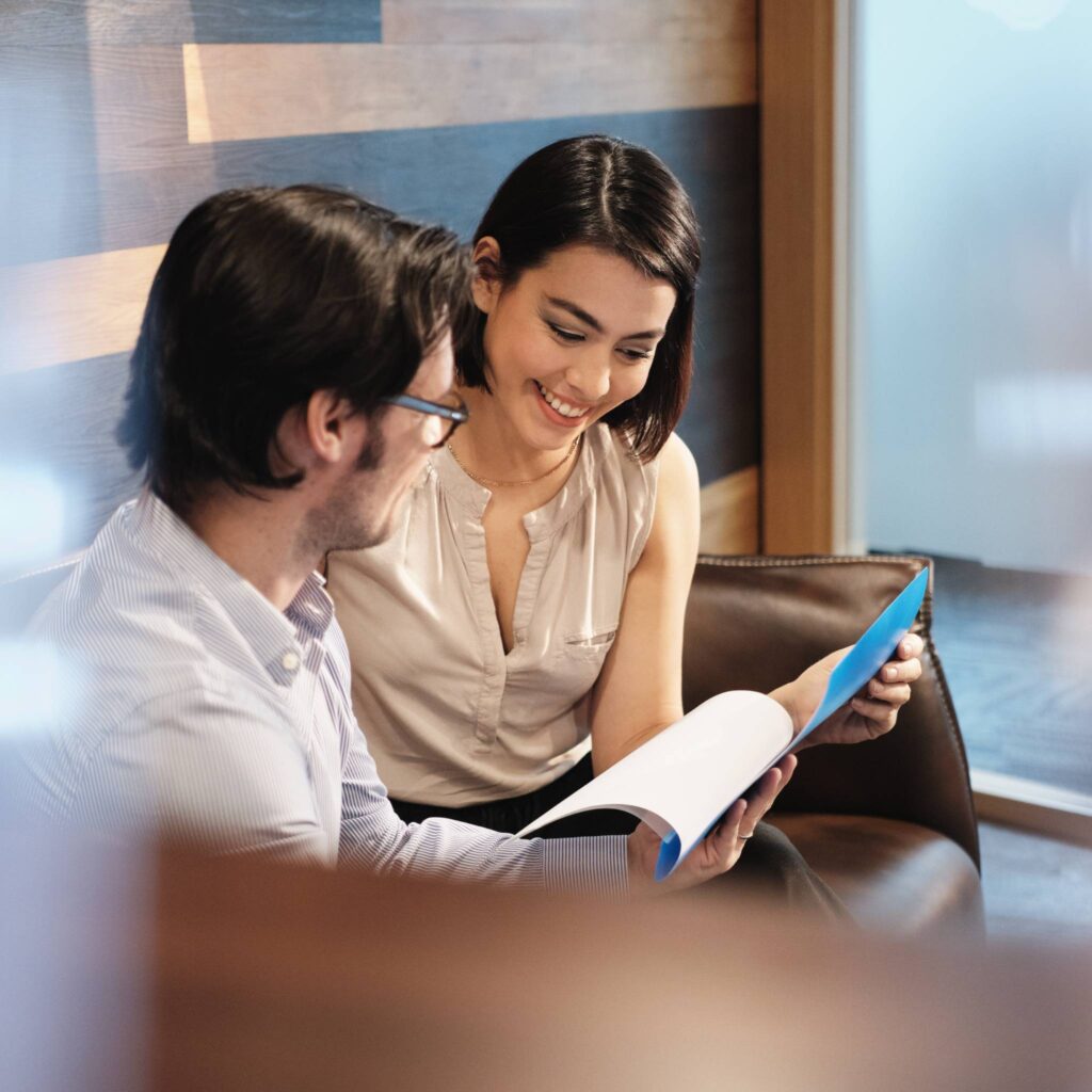 A professional man and woman review paperwork together